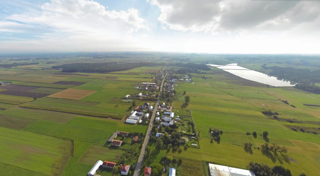 Panorama miejscowości, pól i zbiornika wodnego